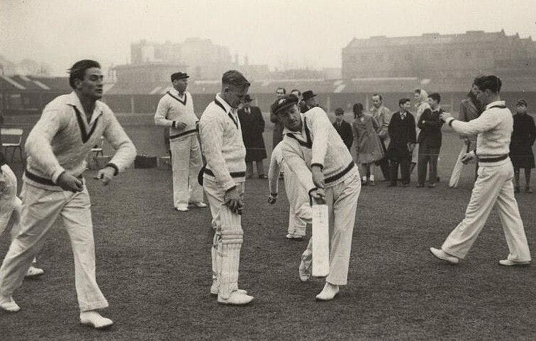 Don Bradman demonstrates a batting point to Colin McCool as Keith Miller prepares to bowl.jpeg