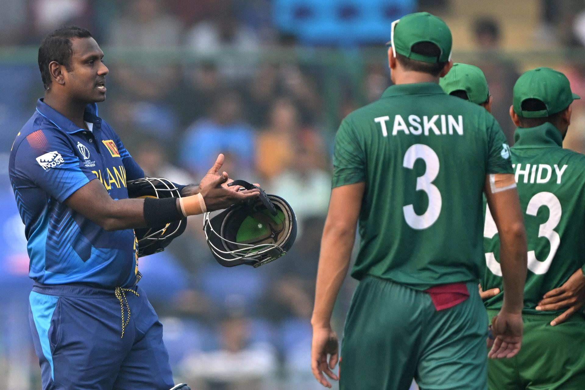 Sri Lanka's Angelo Mathews (L) speaks with Bangladesh's