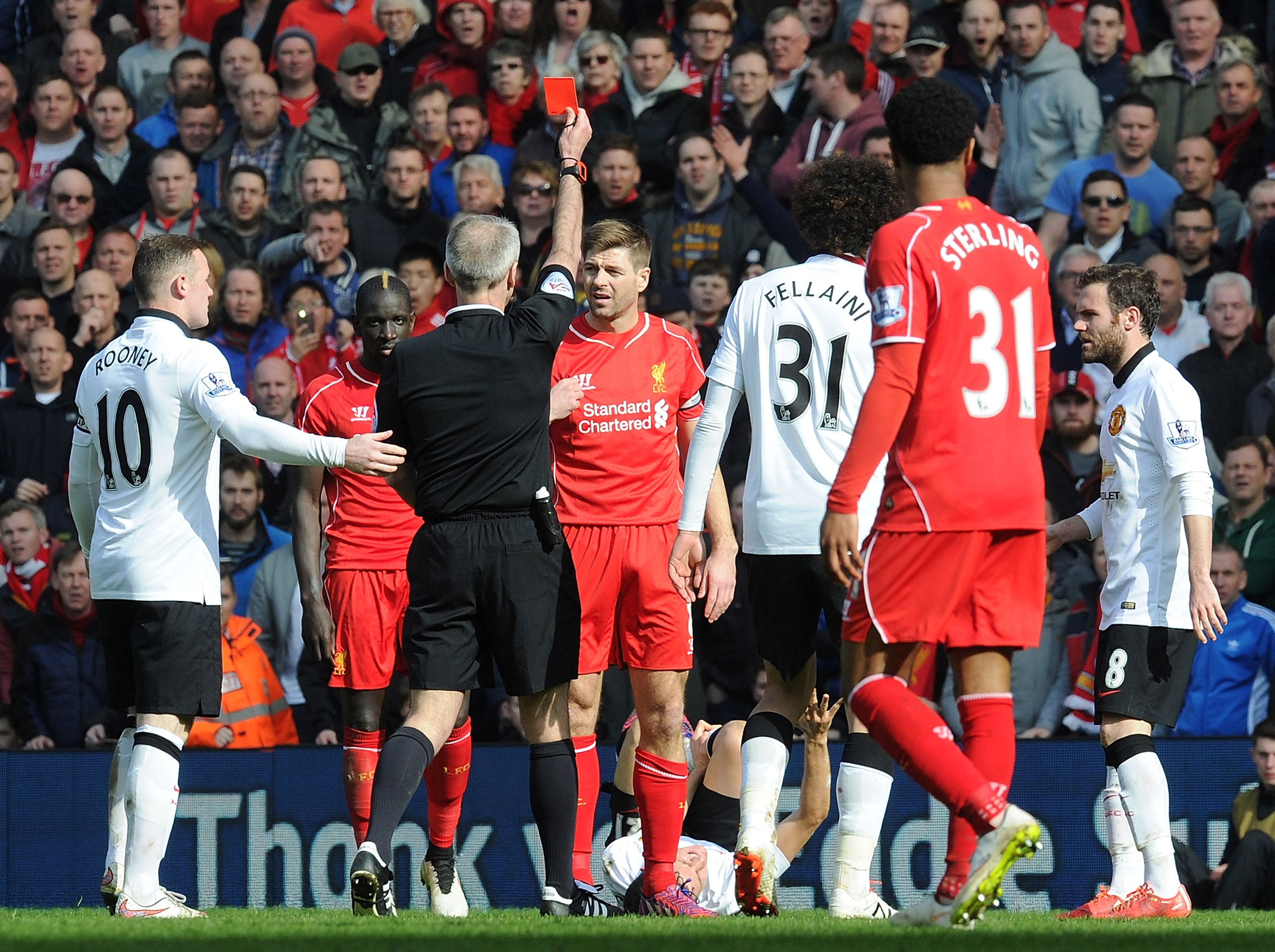 teven Gerrard of Liverpool is shown the red card by referee Martin Atkinson during the Barclays Premier League match between Liverpool and Manchester United at Anfield