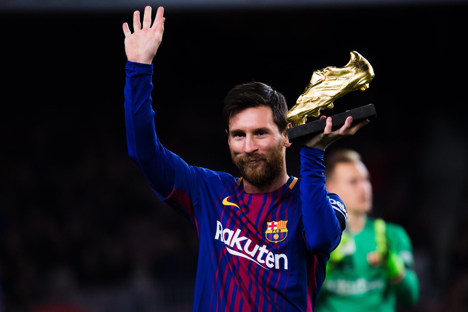 Lionel Messi of FC Barcelona holds the Golden Boot trophy 