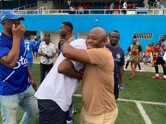 Nigerian legends Finidi George (white) and Emmanuel Amuneke (brown) embrace during an Enyimba FC fixture 
