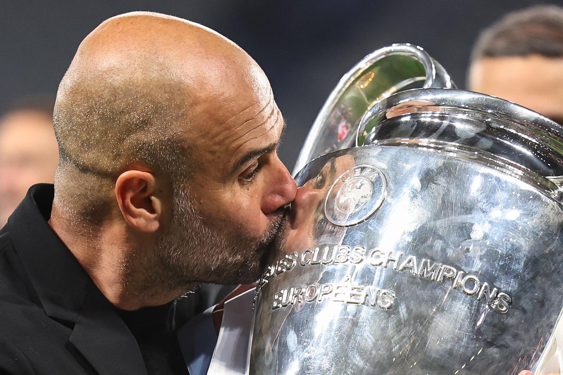 Pep Guardiola kisses the UEFA Champions League trophy 