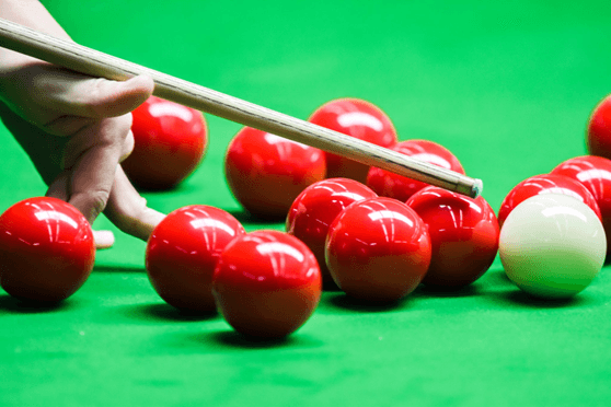 Snooker balls and a cue being held by a player
