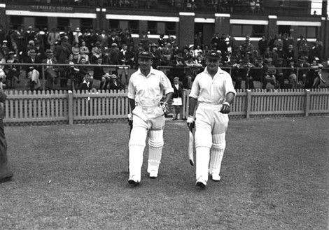 Bradman (left, with his vice-captain Stan McCabe) walks out to bat at Perth