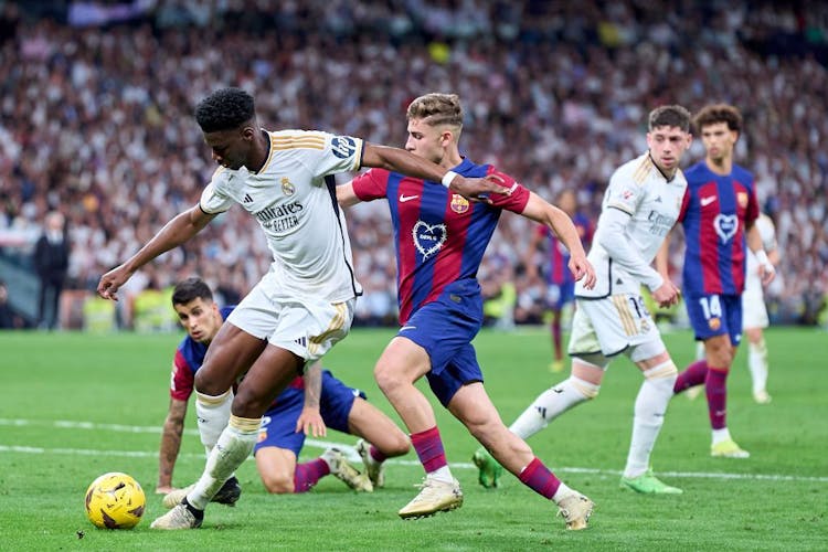 Aurelien Tchouameni of Real Madrid is challenged by Fermin Lopez of FC Barcelona during the LaLiga EA Sports match