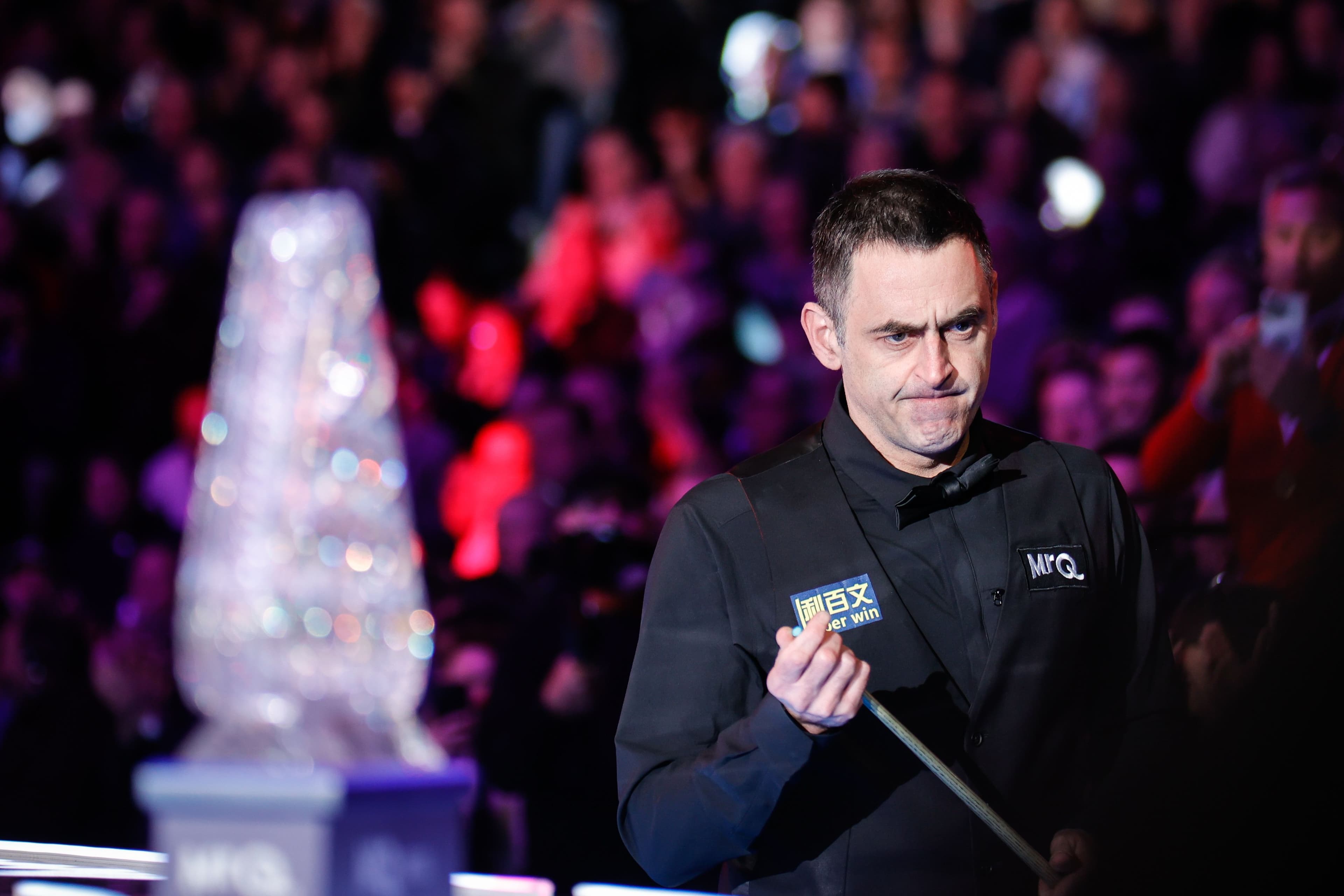 Snooker player sharpening his cue stick