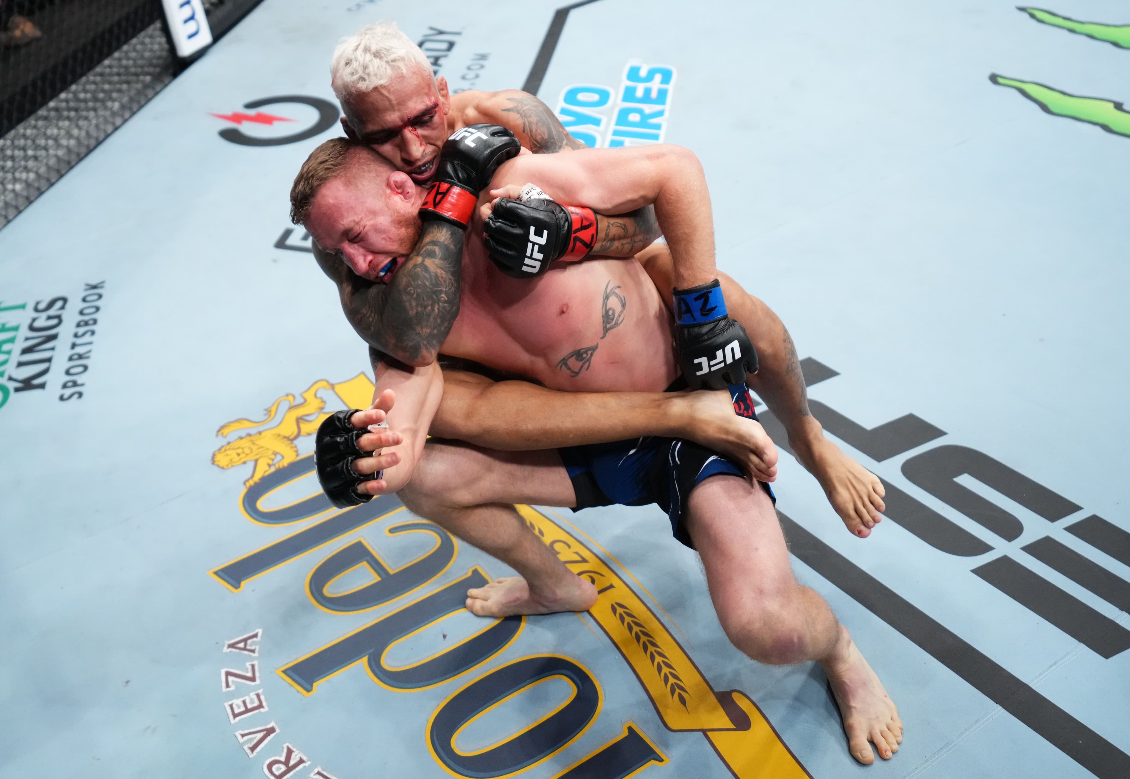 Charles Oliveira of Brazil secures a rear choke submission against Justin Gaethje in the UFC 