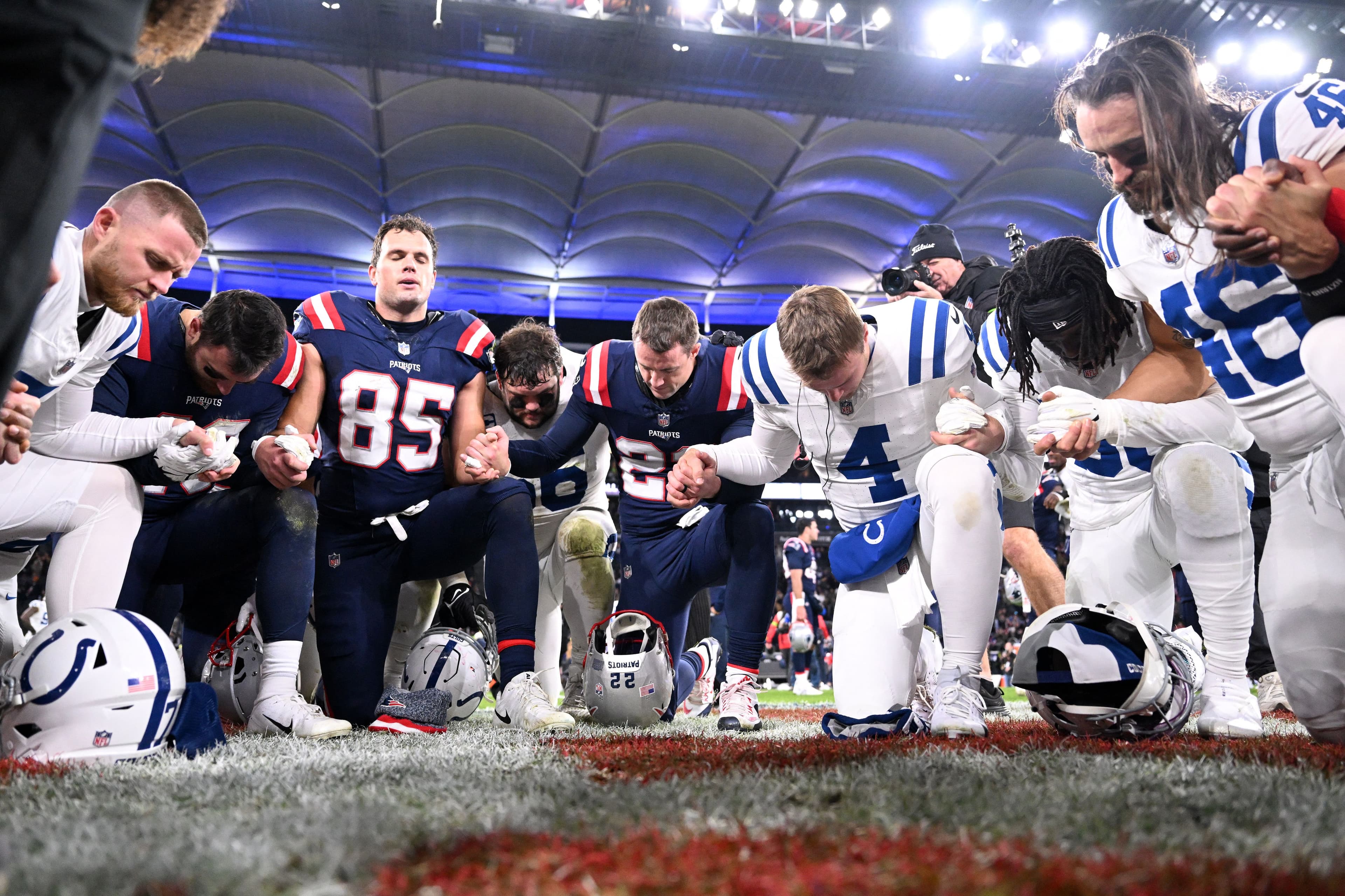 Players of both teams kneel and pray after the NFL American football match Indianapolis Colts 