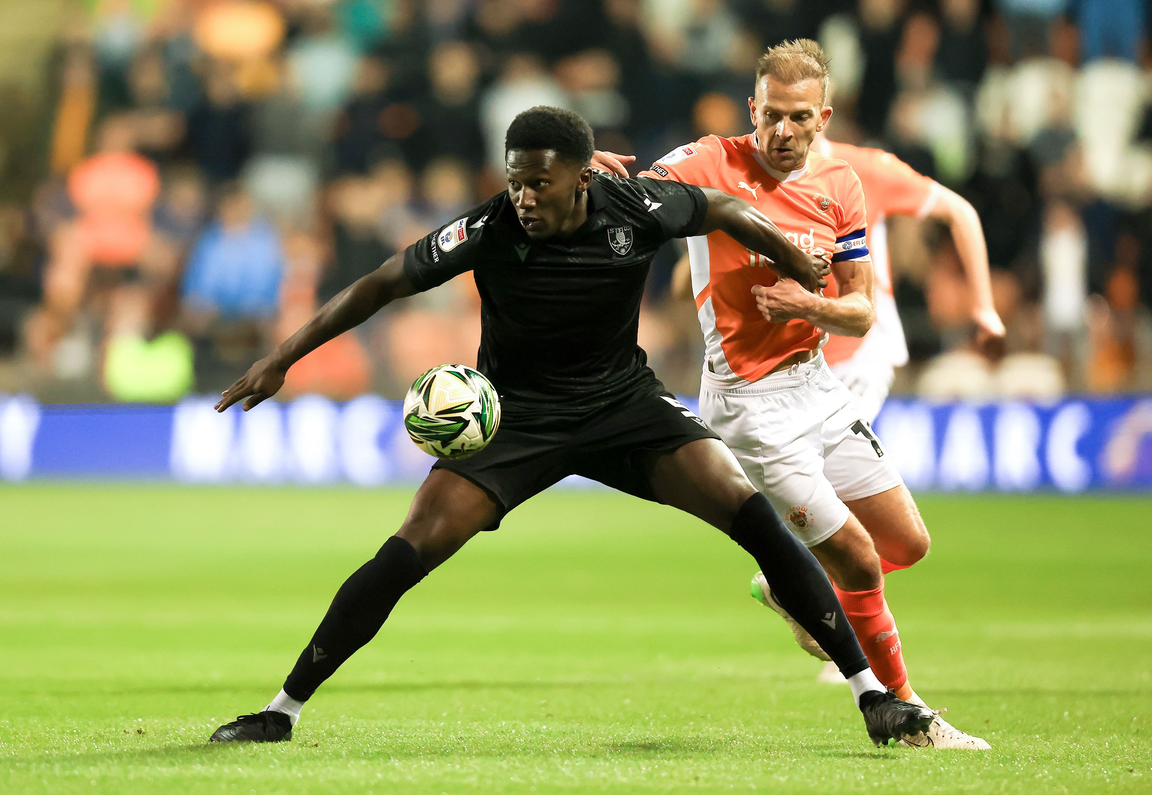 Shon Bernard of Sheffield Wednesday is challenged by Jordan Rhodes of Blackpool during the Carabao Cup 