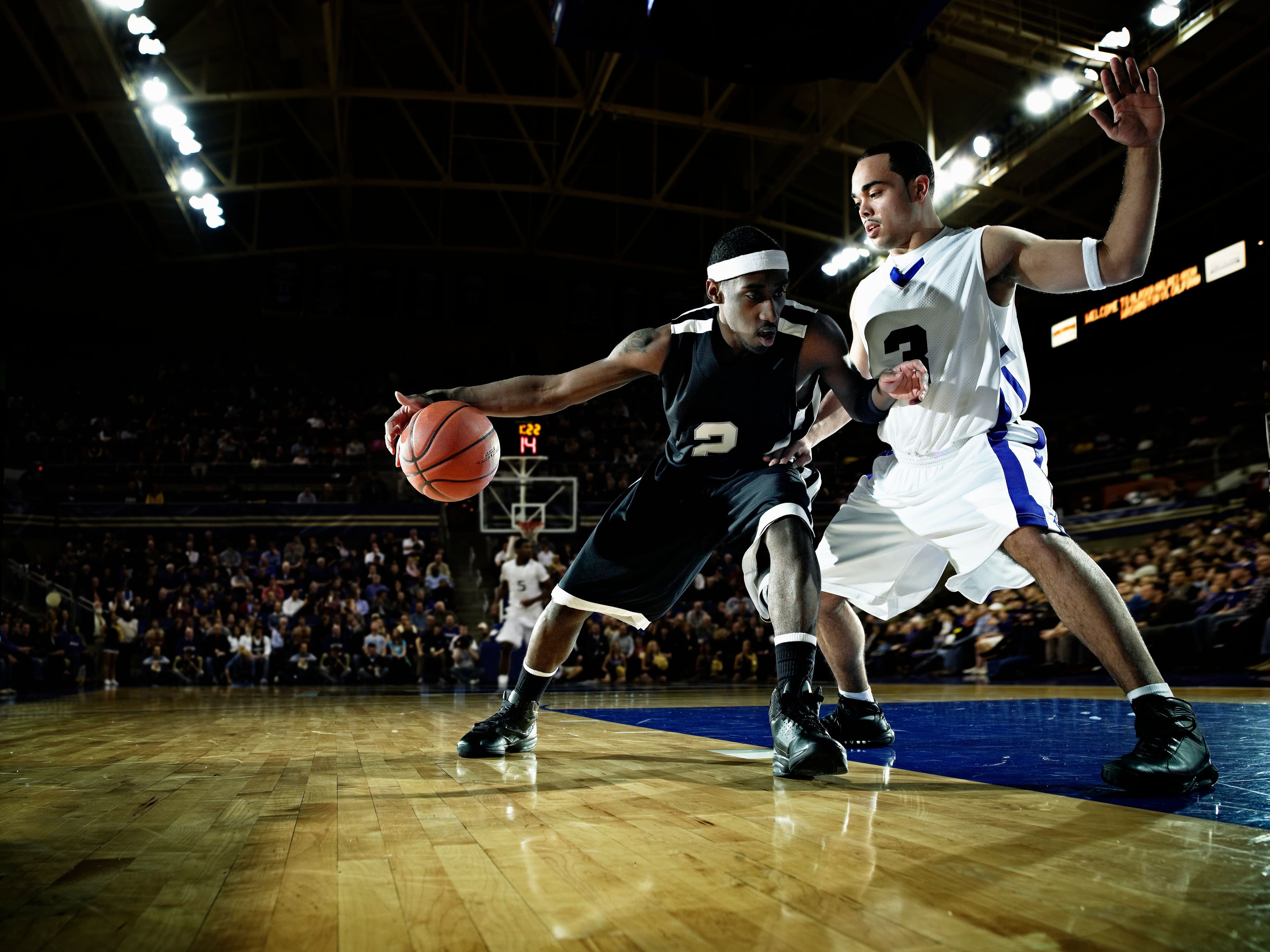 Professional basketball player dribbling basketball on court