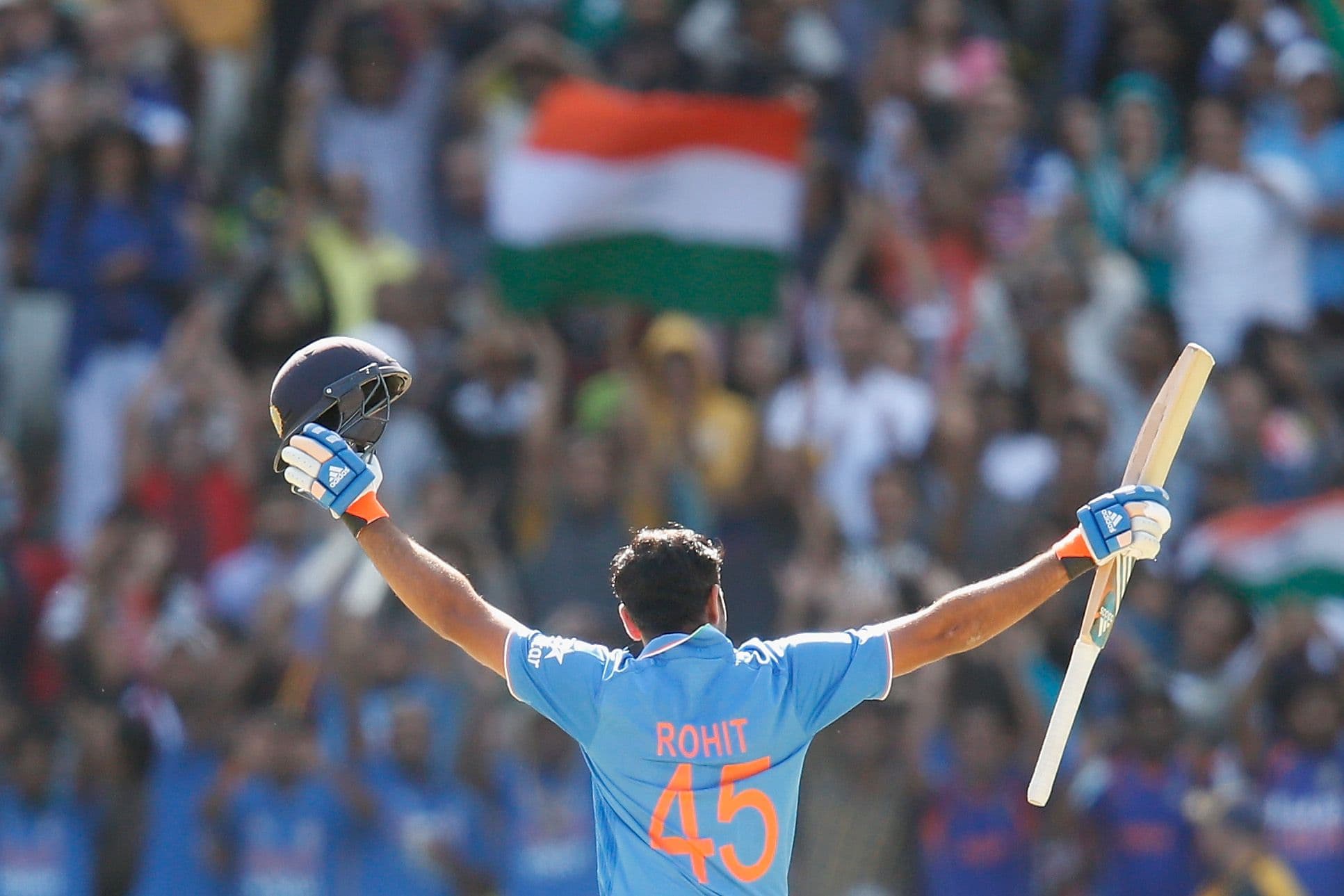 Rohit Sharma of India raises his bat after scoring 100