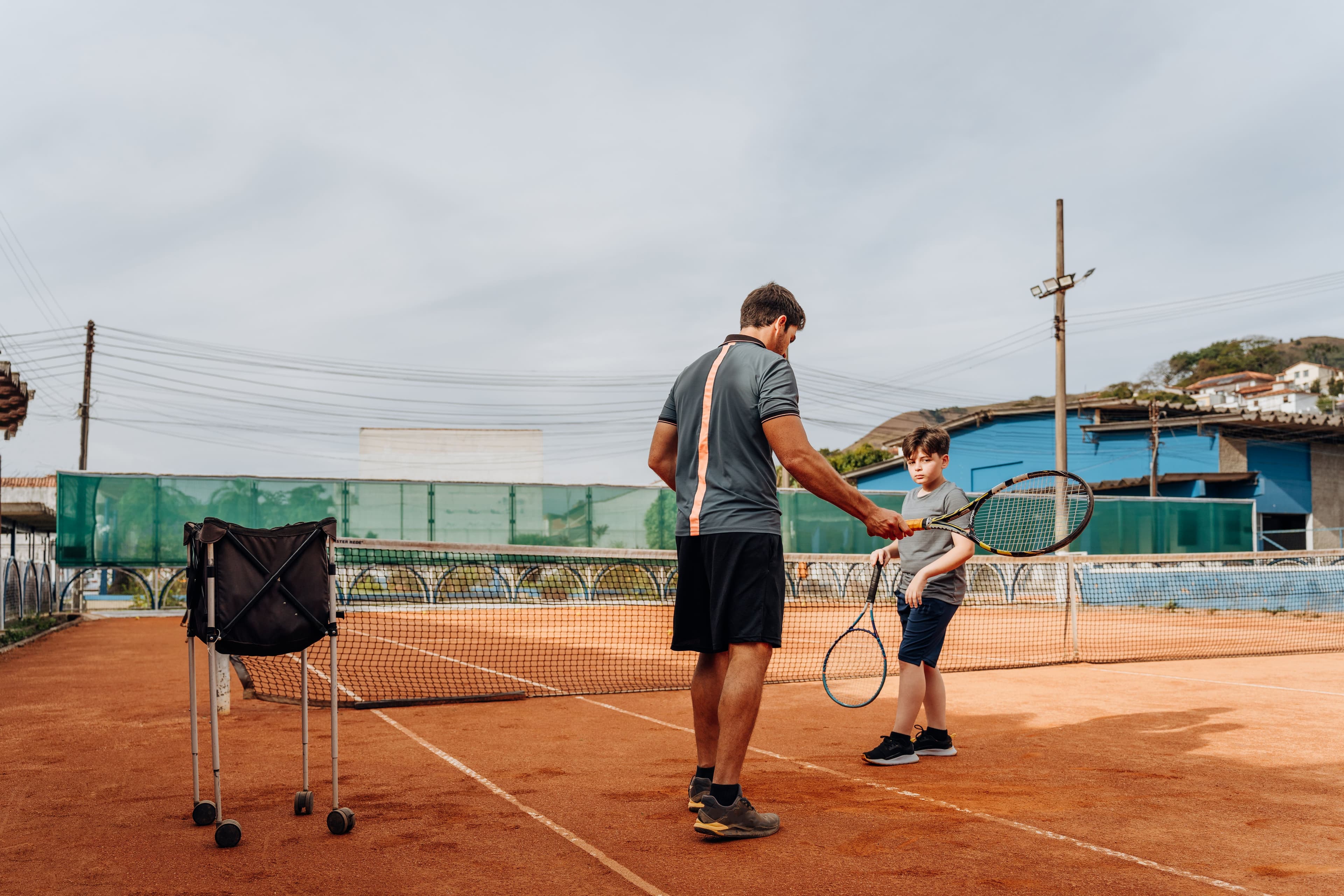 Tennis instructor teaching boy