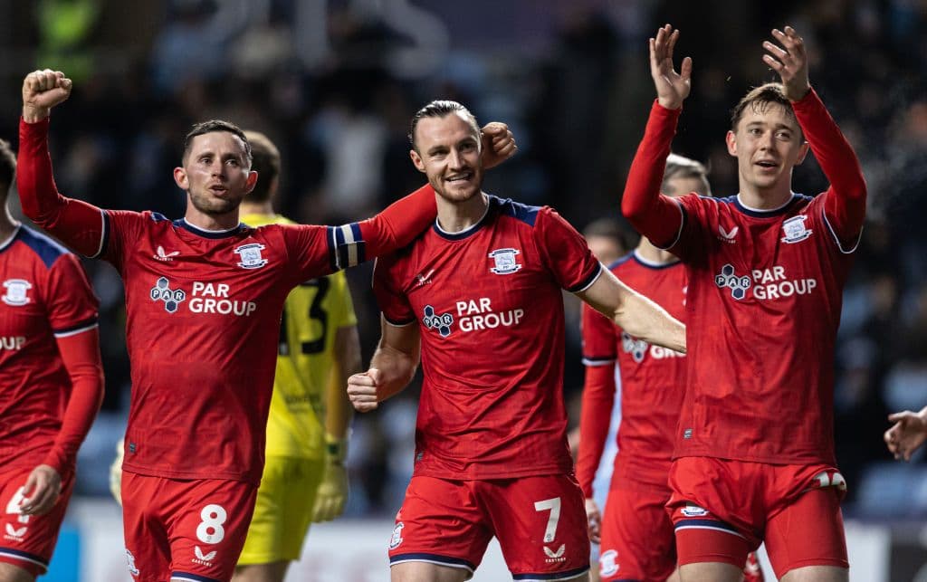 Will Keane celebrating scoring a goal with teammates for Preston North End in an EFL Championship match