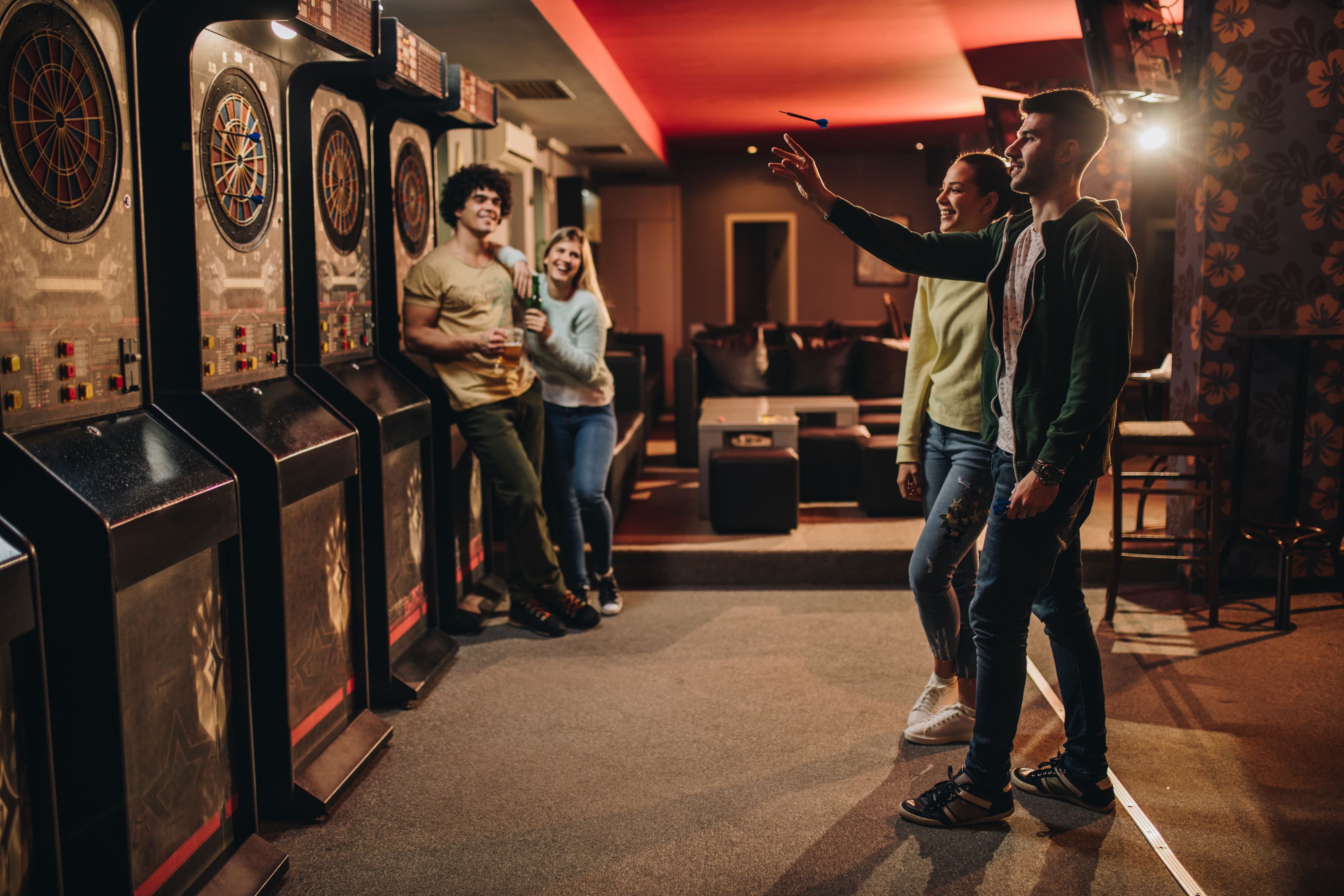 couple playing darts in a bar