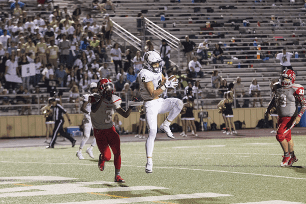 man-catching-brown-football-on-stadium