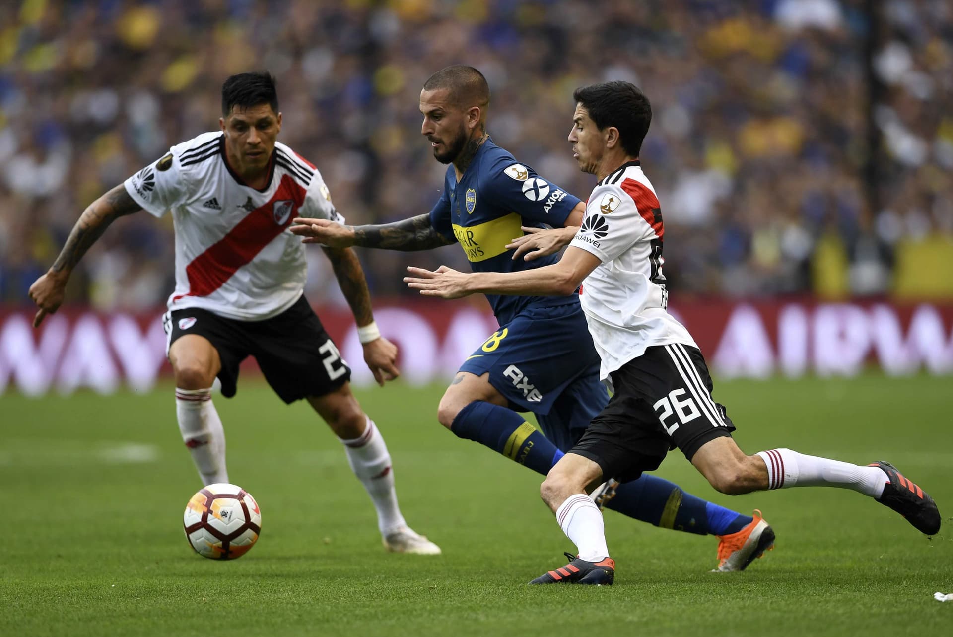Boca Juniors' Dario Benedetto (C) is marked by River Plate's Enzo Perez (L) and Ignacio Fernandez.jpg