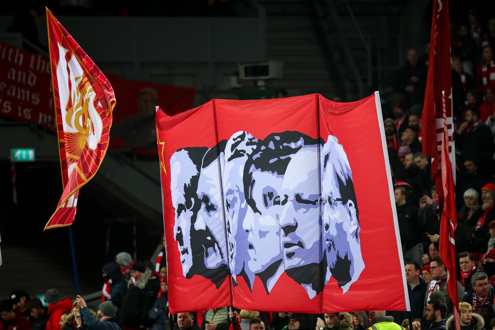 Fans of Liverpool hold up a banner of past managers during the Premier League match