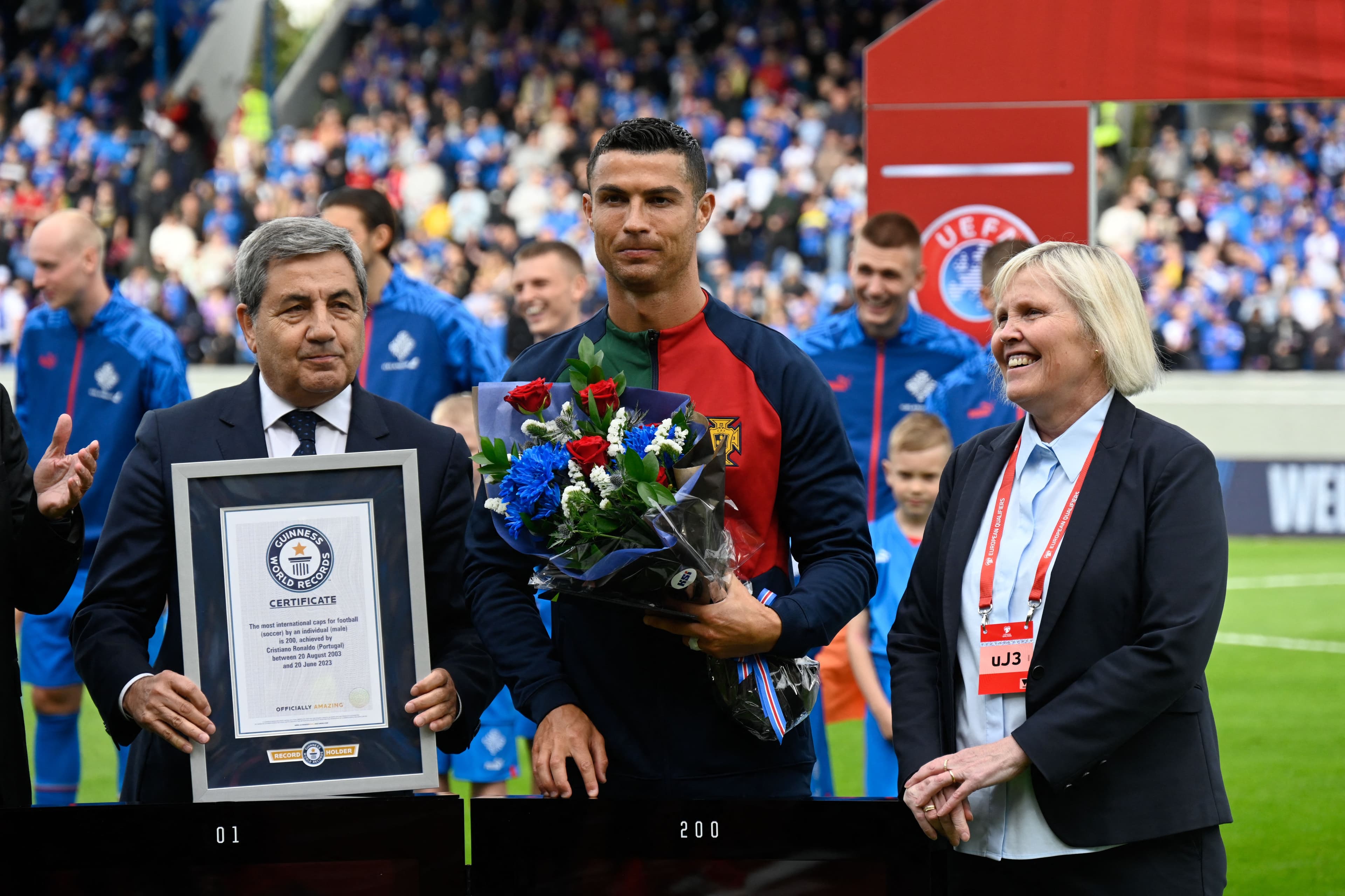 Portugal's forward Cristiano Ronaldo (C) is honoured with a certificate of the Guinness World Records